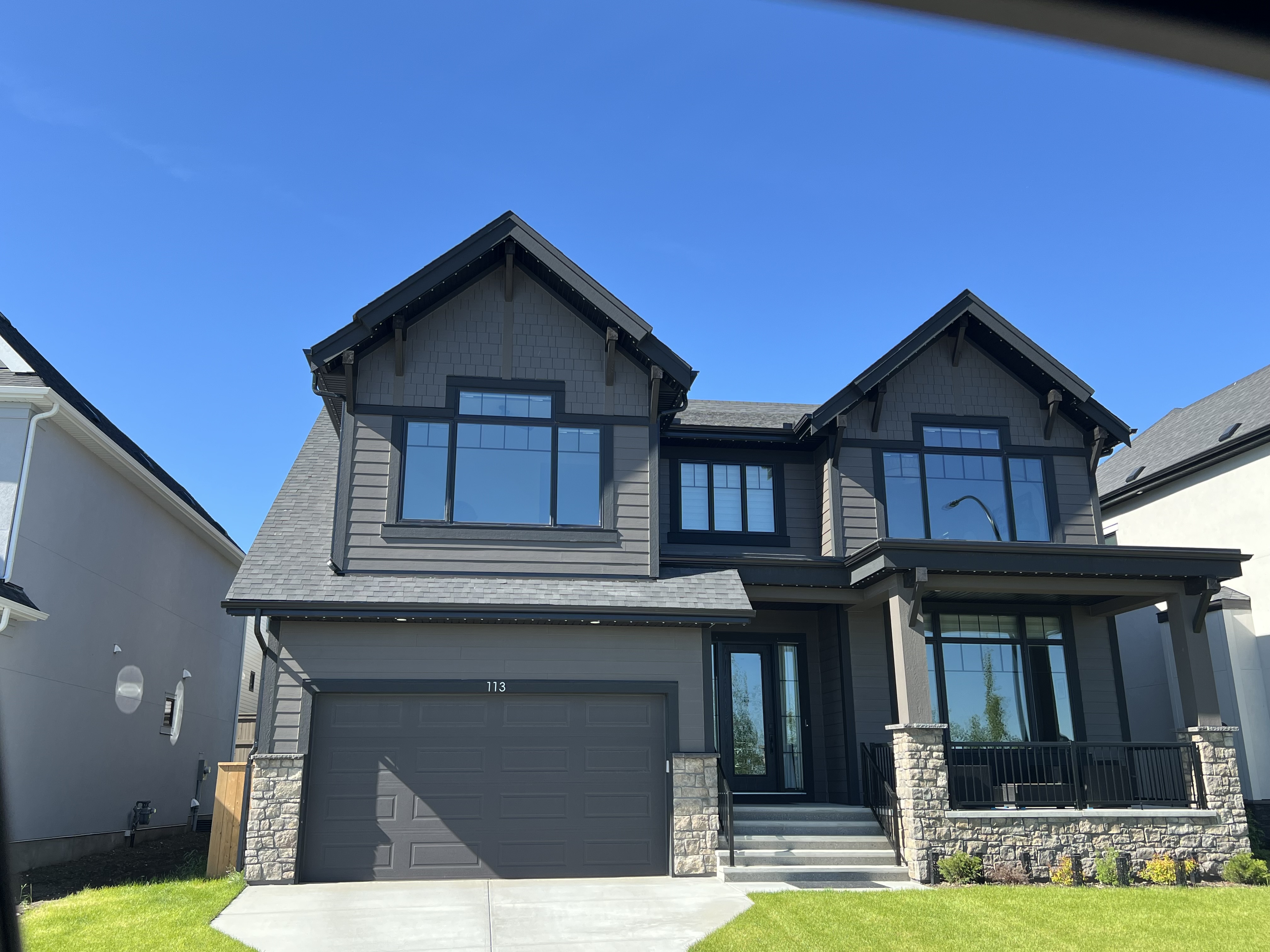Completed Calgary exterior with dark siding and stone accents